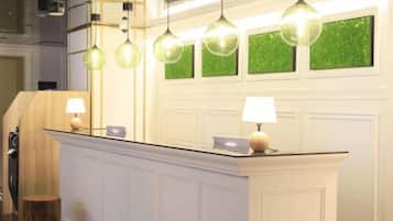 A reception area with a counter, pendant lights, and a wall with green decorative panels.