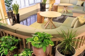 Un espace de détente moderne avec des sièges disposés en arc de cercle, une table ronde et des plantes en pot.