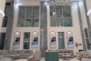 Un hall amplio con techos altos, ventanas grandes y mobiliario moderno.
