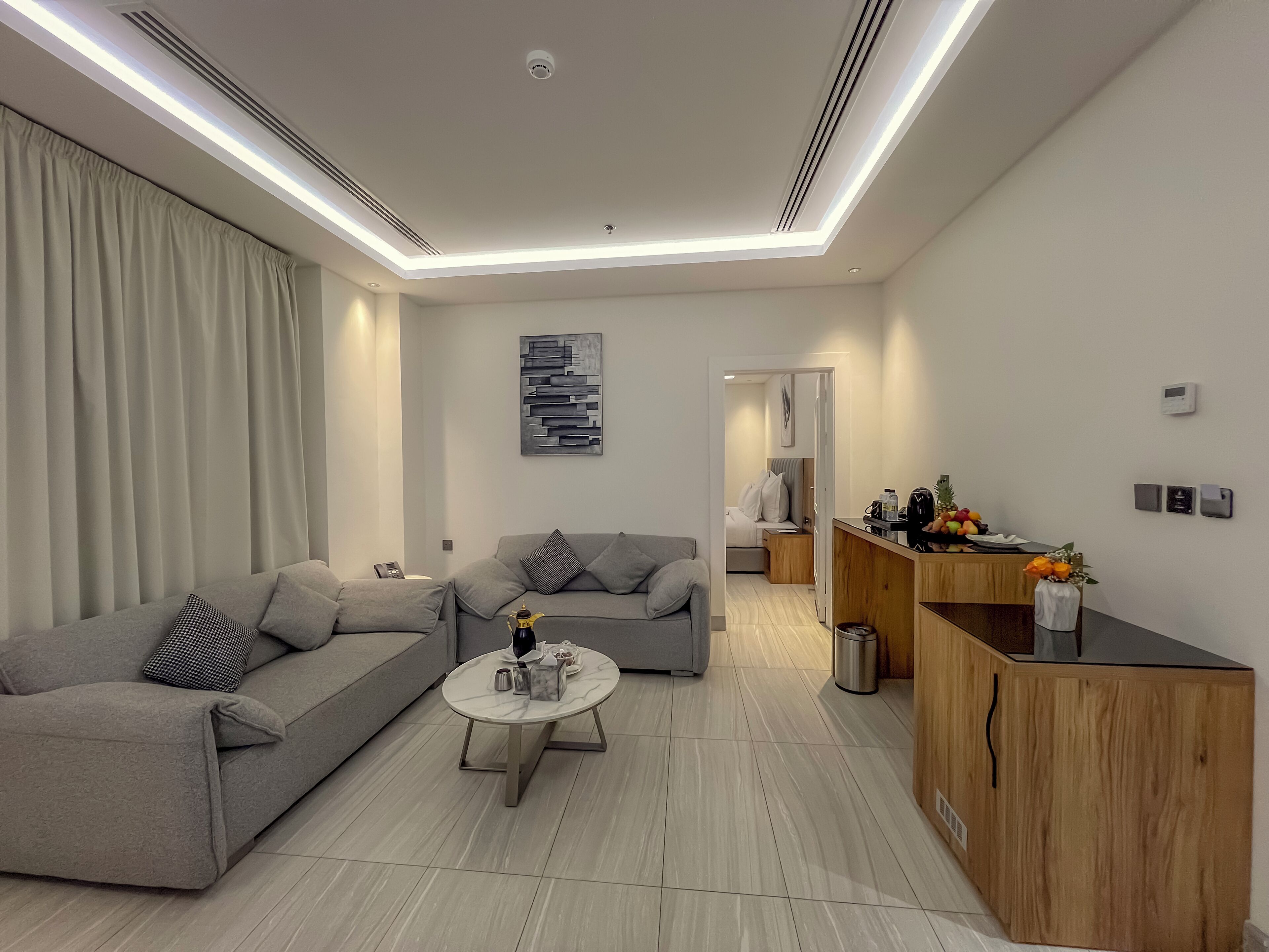A modern living room with a grey sofa, a coffee table, and a wooden cabinet.