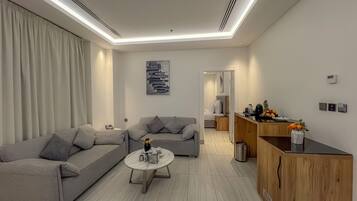 A modern living room with a grey sofa, a coffee table, and a wooden cabinet.