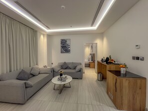 Ein modernes Wohnzimmer mit einem grauen Sofa, einem Couchtisch und einer Holzkommode.