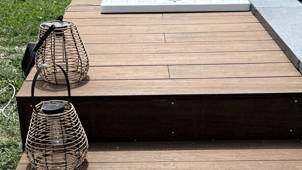 A wooden deck with two wicker lamps and a small bottle. - Maison Individuelle. Animaux de Compagnie Acceptés (Sainte-Cécile-les-Vignes)