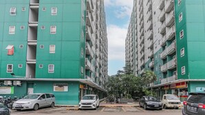 A multi-story residential building with balconies and a green facade. - Hotel O Dms Property (Bekasi)
