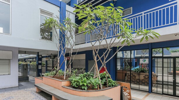 A courtyard with a seating area, plants, and a gated entrance. - Hotel O Dms Property (Bekasi)