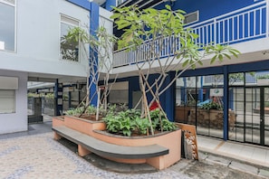 A courtyard with a seating area, plants, and a gated entrance. - Hotel O Dms Property (Bekasi)