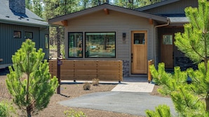A cabin with a stone chimney, large windows, and a wooden door. - Peaceful Nature Escape with Access to Forest House (Bend)
