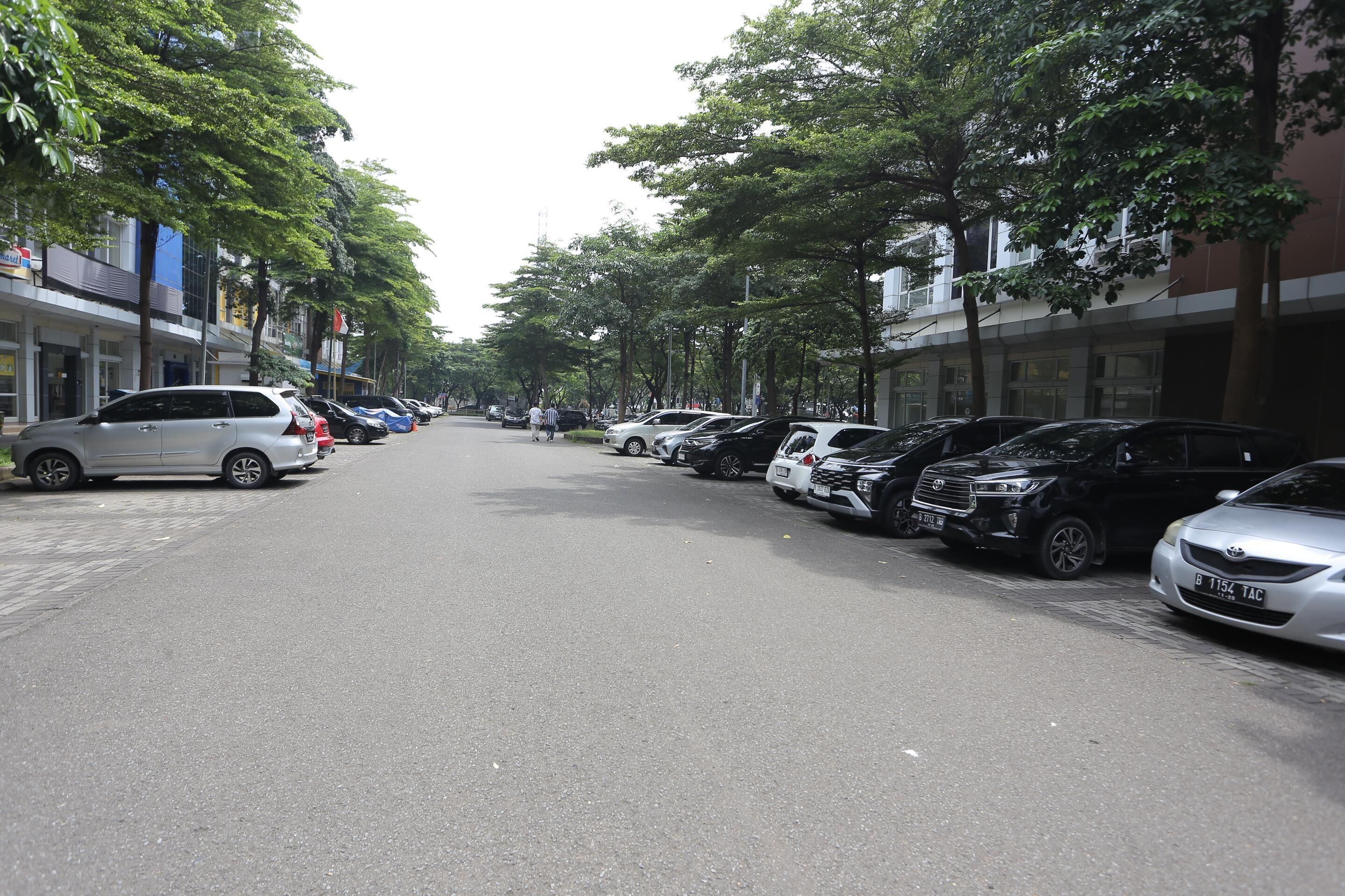 Een straat met geparkeerde auto's en gebouwen aan beide kanten.