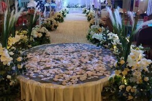 A circular area covered with rose petals, surrounded by floral arrangements. - Chenxu Hotel (Wanyuan)