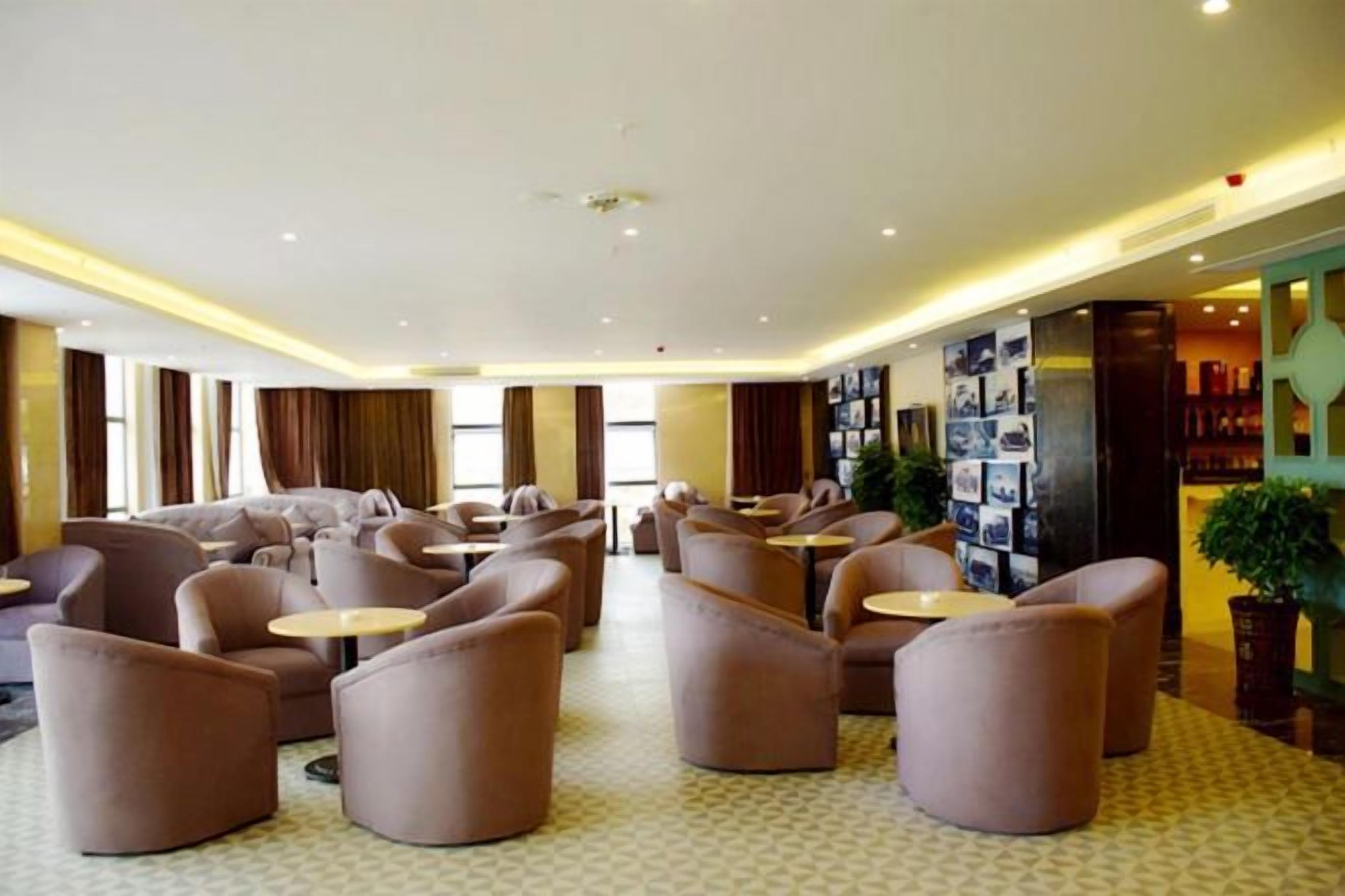 A hotel lobby with sofas, tables, and a wall with photos.