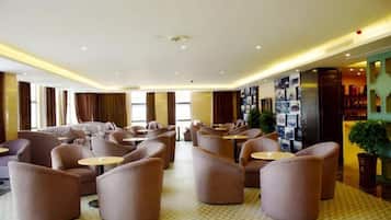 A hotel lobby with sofas, tables, and a wall with photos.