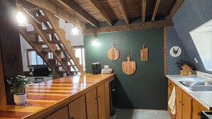 A kitchen with wooden cabinets, a wooden countertop, a coffee maker, and a window. - Big Barn in Bemus Point, unique, peaceful, and memorable (Bemus Point)