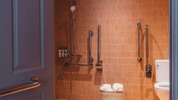 Un bagno con doccia, WC e un cesto con asciugamani.