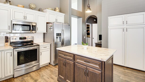 A modern kitchen with white cabinetry, stainless steel appliances, and a marble island. - Stunning Oro Valley Home: Near Catalina State Park (Oro Valley)