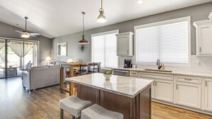 A spacious kitchen with a central island, wooden flooring, and white cabinetry. - Stunning Oro Valley Home: Near Catalina State Park (Oro Valley)