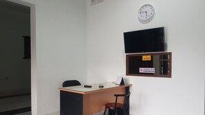 Un mostrador de recepción con un reloj y una televisión montada en la pared.