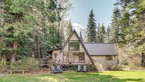 A cabin with a sloped roof, large windows, and a deck with chairs. - Cle Elum A-frame - Direct Yakima River Access! (Cle Elum)