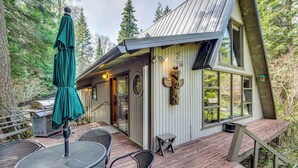 A wooden deck with outdoor seating and a grill, surrounded by trees. - Cle Elum A-frame - Direct Yakima River Access! (Cle Elum)