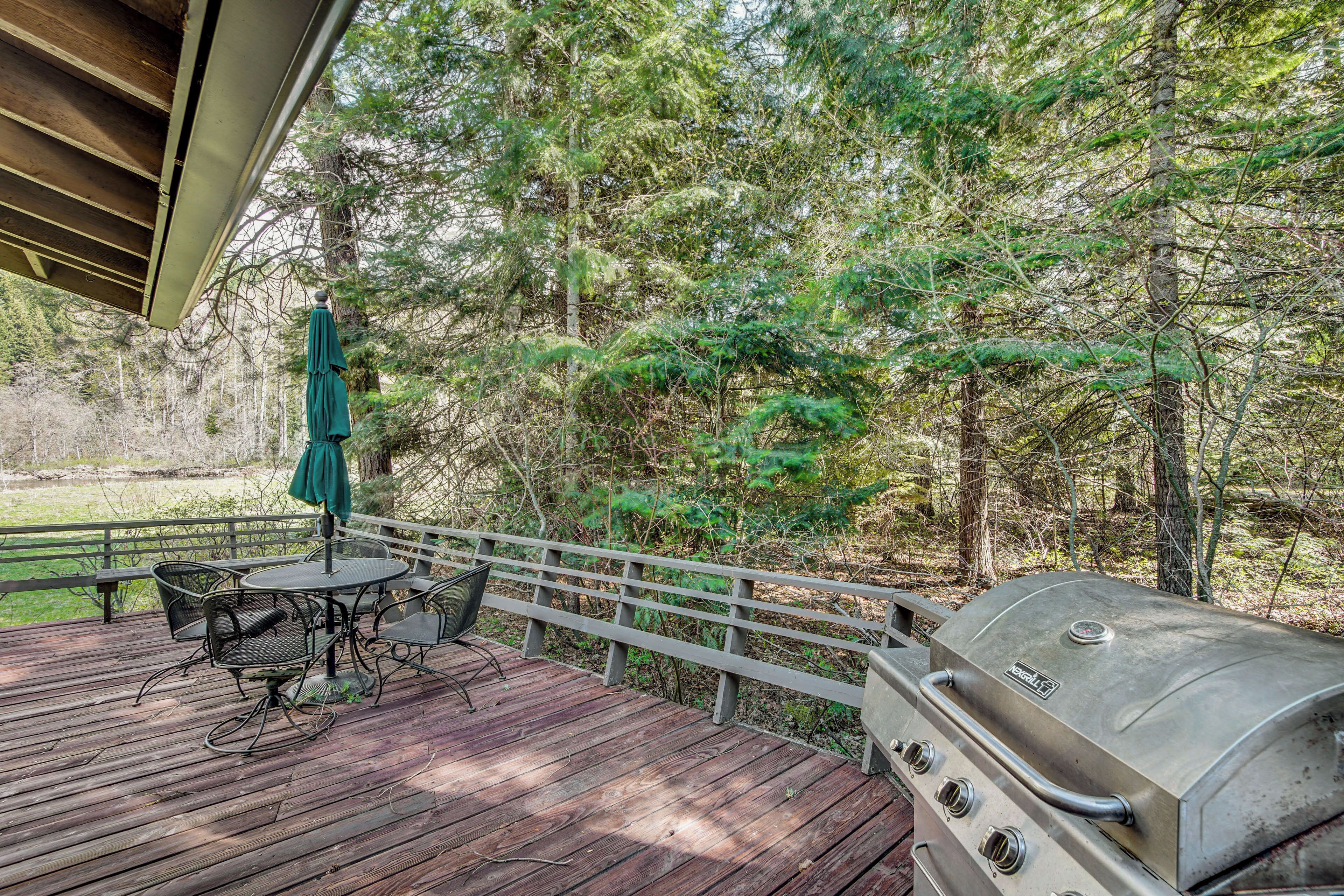 A wooden deck with a grill and outdoor furniture.