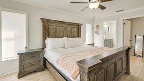 A bedroom with a wooden bed frame, a nightstand, a ceiling fan, and a large window with blinds. - Furnished Outdoor Area! Family Home in Spring Hill (Spring Hill)