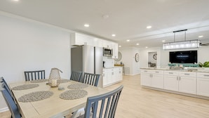 A modern kitchen with white cabinets, a built-in microwave, and a large island with a sink. - Furnished Outdoor Area! Family Home in Spring Hill (Spring Hill)