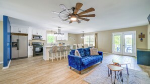 Eine moderne Küche mit Einbauofen, Mikrowelle und Kühlschrank. Es gibt einen Essbereich mit einem blauen Sofa und einem kleinen Tisch.