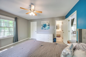 A bedroom with a bed, a ceiling fan, a dresser, a window with curtains, and a door leading to another room. - Milledgeville Home w/ Game Room & Private Dock! (Milledgeville)