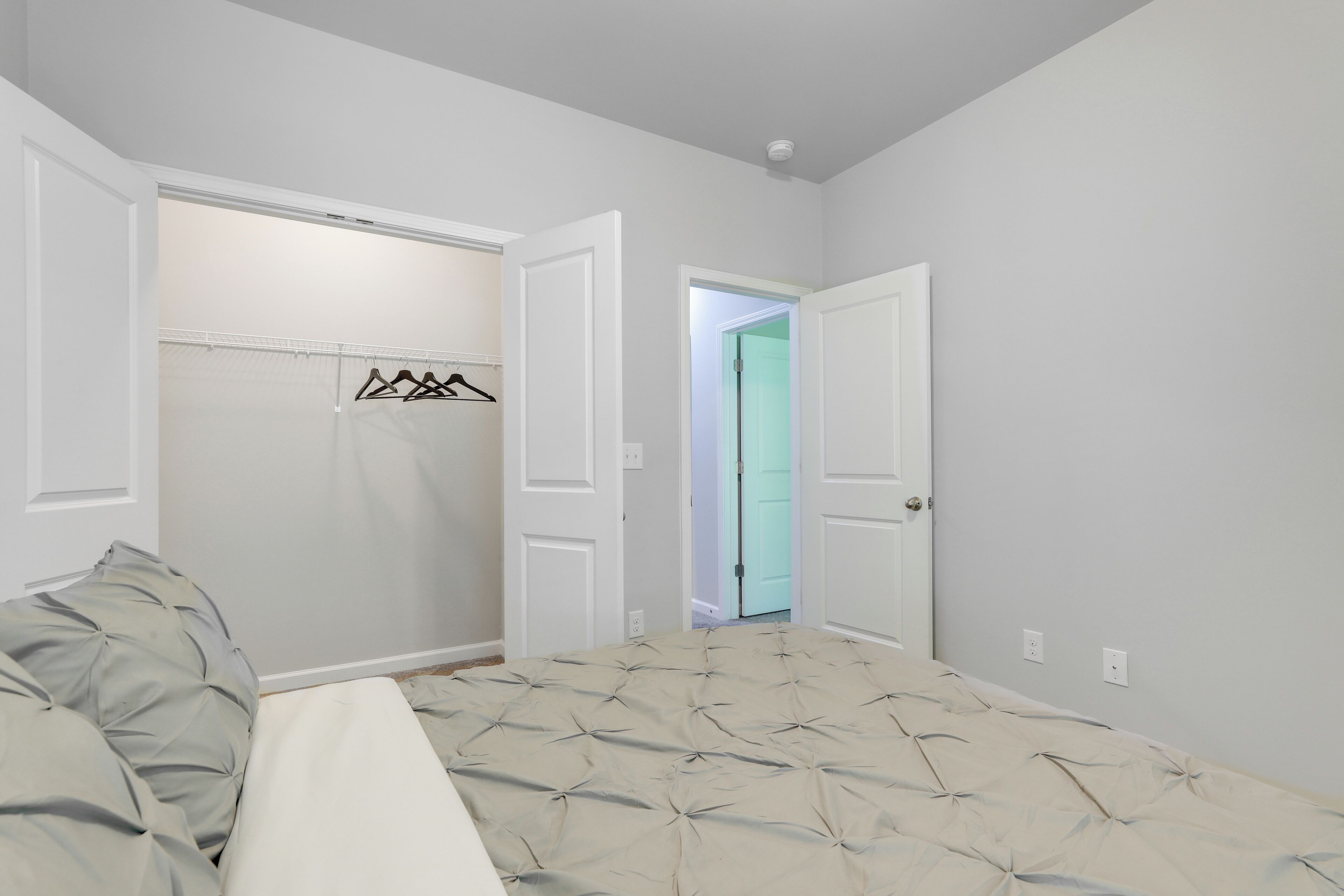 Un dormitorio con cama, armario y dos puertas que dan a otras habitaciones.