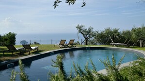A swimming pool with lounge chairs and a view of the ocean. - Charming Villa with Pool, Overlooking the Enchanting Galli Islands (Amalfi)