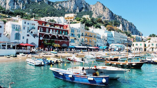 A coastal town with boats docked at the harbor, buildings with balconies, and a mountainous backdrop. - Charming Villa with Pool, Overlooking the Enchanting Galli Islands (Amalfi)