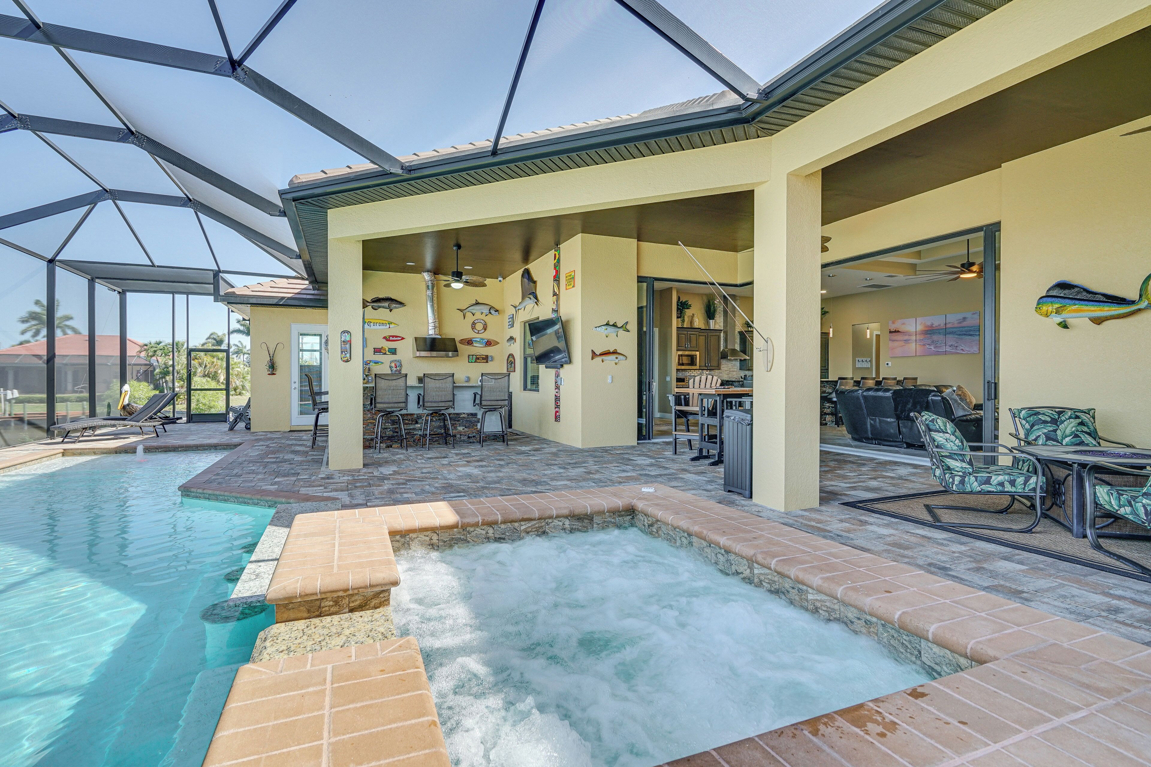 A covered outdoor pool area with a hot tub, seating, and a dining area.