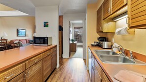 Una cocina moderna con armarios de madera, microondas, tostadora y lavamanos.