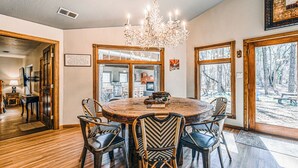 A dining area with a round wooden table, six chairs, and a chandelier.