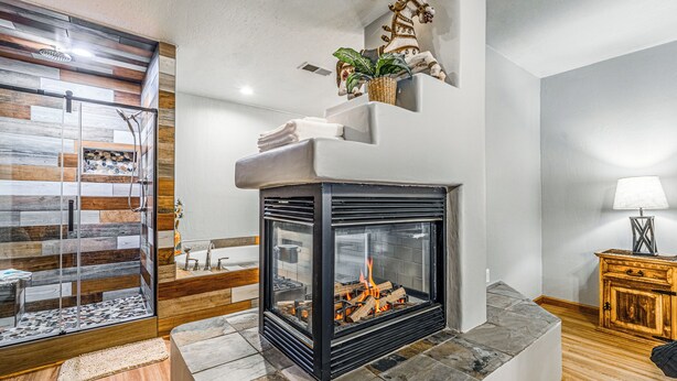 A modern living room with a fireplace, a glass shower enclosure, and a wooden cabinet.