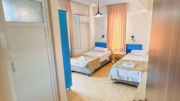 A hotel room with two beds, a bathroom, and a hallway.