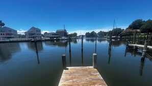 A wooden dock extending into calm water with buildings in the background. - SunsetSanctuary-CanalFront/DogFriendly/Pool&Tennis (Kill Devil Hills)