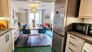 Una cocina moderna con comedor, electrodomésticos de acero inoxidable y vistas a la ciudad.