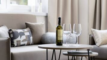 Una botella de Pinot Grigio Garde sobre una mesita redonda con dos copas de vino.