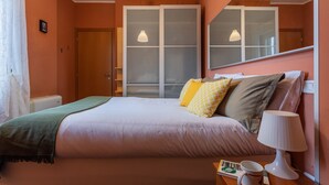 A bedroom with a bed, bedside lamp, and a window with frosted glass. - Sui tetti di Torino by Wonderful Italy (Torino)