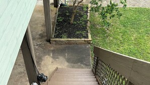 Un escalier en bois menant à un espace abrité avec un jardin.