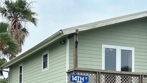 Une maison avec un porche, une balançoire et un panneau de signalisation indiquant la 14e rue et l’avenue Van Buren.