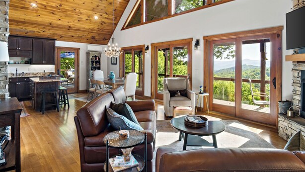 A spacious living area with a high ceiling, wooden beams, a large sofa, a coffee table, and a fireplace. - Welcome to Grandview Lodge! A 4 bedroom, 4 bath Mountain Sanctuary with Mtn View (Nebo)