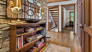 A wooden bookshelf with books, a stone wall, and a wooden staircase. - Welcome to Grandview Lodge! A 4 bedroom, 4 bath Mountain Sanctuary with Mtn View (Nebo)