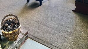 Una habitación acogedora con televisión, muebles de madera, una mesa redonda y ventanas amplias.