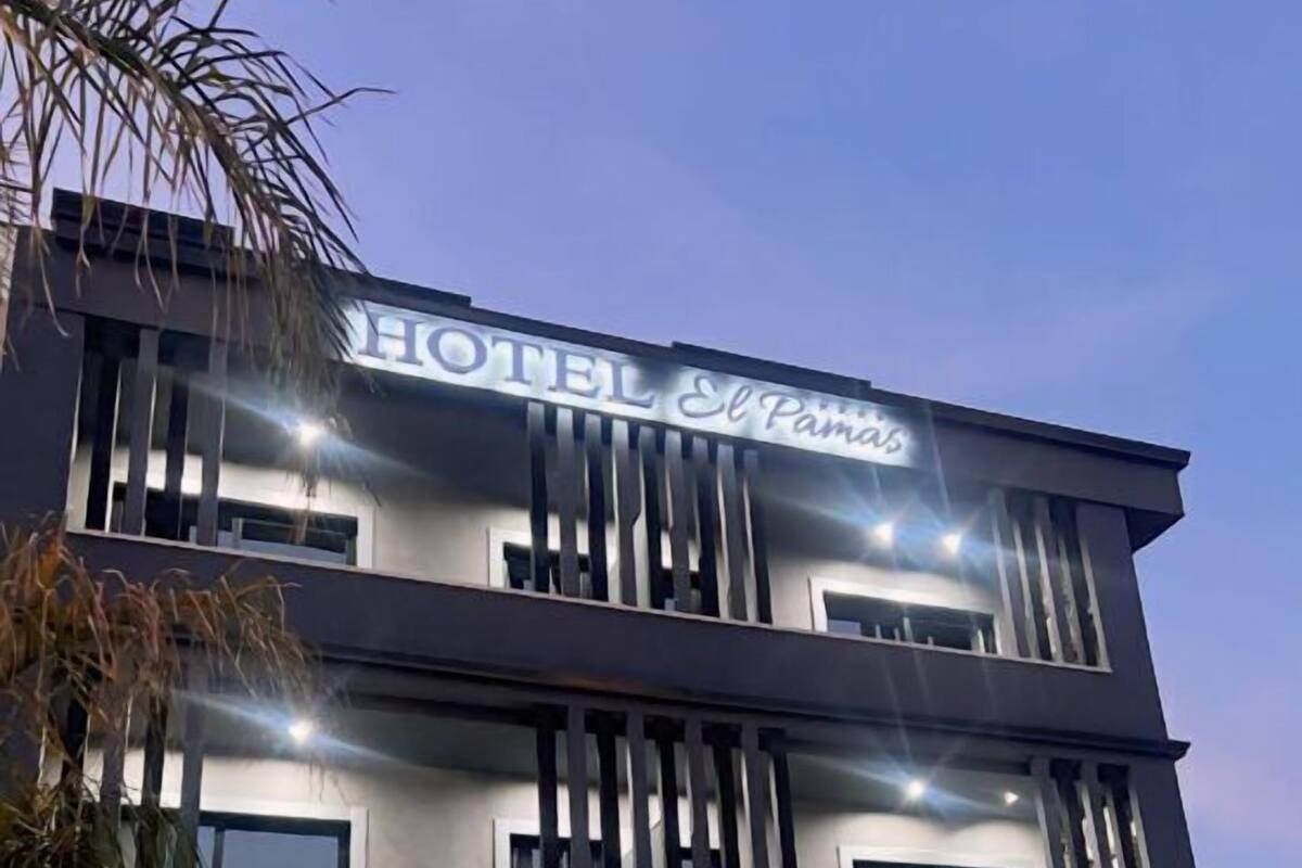 A modern hotel building with a sign reading "HOTEL El Paraiso."