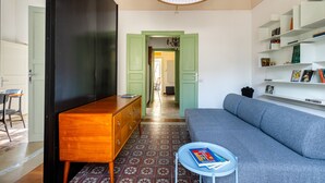 Una sala de estar moderna con un sofá, un aparador de madera y una estantería.