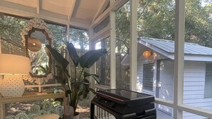 A conservatory with a piano, a mirror, and a lamp. - North End, 3 Br Luxury Cottage, Pet Friendly, Private Road, 5 min walk to Beach (Tybee Island)