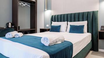 A hotel room with a bed, a wardrobe, a bedside table, and a nightstand.