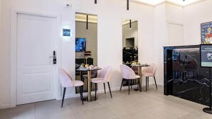 Una camera d'albergo con zona pranzo, televisione, minibar e specchio.
