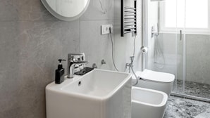 Un bagno moderno con lavandino ampio, servizi igienici e zona doccia.